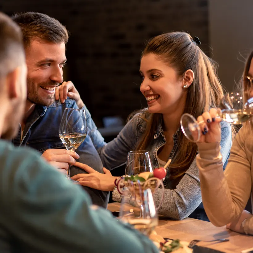 Cena conviviale: colleghi che brindano e ridono a tavola